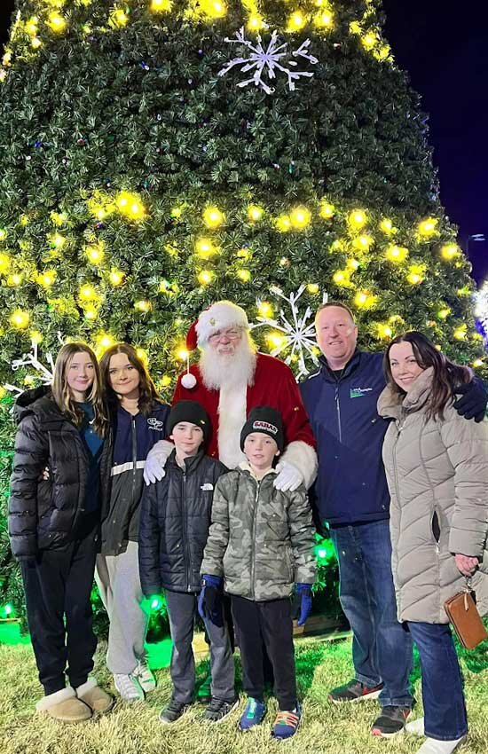 The Sabas family with Santa at Christmas at the Crossings in front of Champlin's community Christmas tree