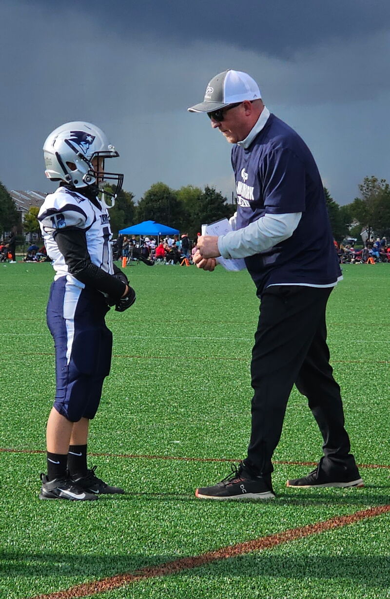 Mayor Ryan Sabas coaching youth football on the sidelines at a Champlin Dayton Athletic Association game